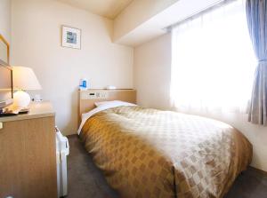 a bedroom with a bed and a desk and a window at Hotel Trend Nagano in Nagano +16 photos