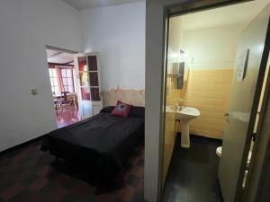 a small room with a bed and a sink at El Viaje Hostel in Mina Clavero +60 photos