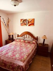 a bedroom with a bed and two night stands with lamps at Cabaña Clarita La Florida in La Florida +14 photos
