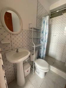 a bathroom with a sink and a toilet and a mirror at Hospedaje vista del sur paracas in Paracas +37 photos