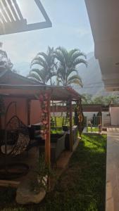 a patio with chairs and a gazebo with palm trees at La casona de aquiles in Palle Nuevo