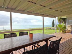 a wooden table on a deck with a view of the ocean at 38 at Point Turton in Point Turton