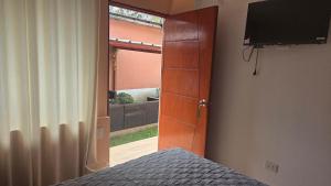 a bedroom with a door and a bed and a television at La casona de aquiles in Palle Nuevo