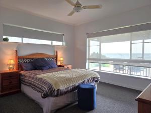 a bedroom with a bed with a view of the ocean at 38 at Point Turton in Point Turton