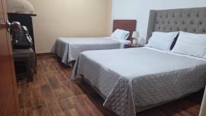 a hotel room with two beds with white sheets at La casona de aquiles in Palle Nuevo