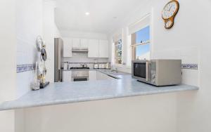 a kitchen with a counter top with a microwave at Ocean Tracks in Kiama