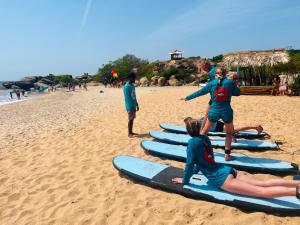 a group of people on surfboards on the beach at Saha surf camp lesson booking only in Pottuvil +121 photos