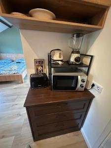 a kitchen counter with a microwave on top of it at Tim's Place in Groesbeek