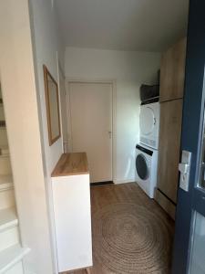 a small room with a kitchen with a microwave at Tim's Place in Groesbeek
