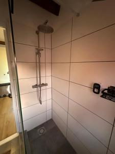 a bathroom with a shower with white tile walls at Tim's Place in Groesbeek