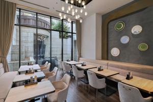 a restaurant with tables and chairs and windows at Hotel Trusty Tokyo Bayside in Tokyo