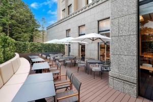 an outdoor patio with tables and chairs and umbrellas at Hotel Trusty Tokyo Bayside in Tokyo +100 photos