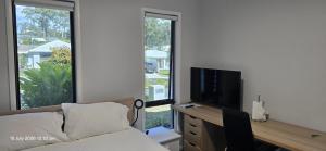 a bedroom with a bed and a desk with a television at Serene Home in Bahrs Scrub