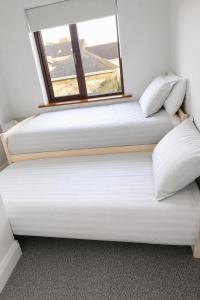 two beds in a room with a window at Ardee Retreat - Sleeps 6, Garden, Walk to Town in Ardee