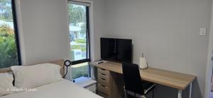 a bedroom with a bed and a desk with a television at Serene Home in Bahrs Scrub