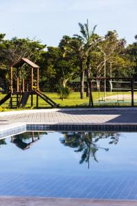 a swimming pool with a slide and a playground at Ap do Maro in Barreirinhas