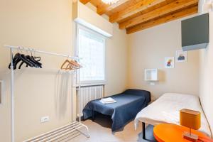 a room with a bed and a table and a window at Casa con ampio terrazzo, vista lago e giardino in Toscolano Maderno