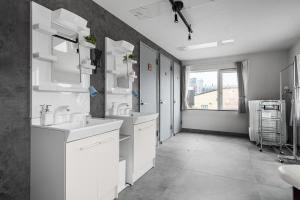 a white bathroom with two sinks and a window at Snowm in Asahikawa