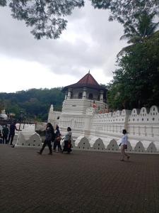 a group of people walking in front of a white building at Padiwatte Residencies in Kandy +27 photos