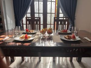 a table with plates of food on top at RKM Hotel Uppuveli in Trincomalee
