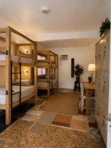 a room with bunk beds and a desk at Casa Alegria Beach Rooms in Alegria