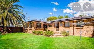 a brick house with a lawn in front of it at The Nest in Bidwill +8 photos