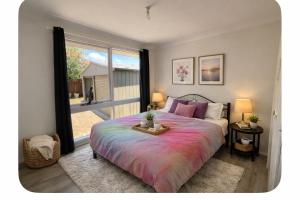 a bedroom with a large bed and a large window at The Nest in Bidwill