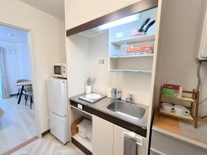 a small kitchen with a sink and a refrigerator at 海しずく Slow in Amakusa