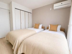 two beds sitting next to each other in a room at 海しずく Slow in Amakusa