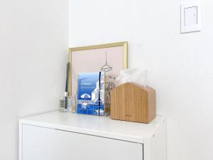 a shelf with a box on top of a white dresser at 海しずく Slow in Amakusa +36 photos