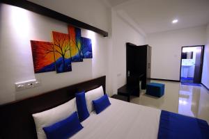 a bedroom with a bed and a painting on the wall at City Stay in Galle