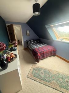 a bedroom with a bed in a room with a window at Laimhrig Lockley in Torrin