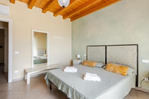 a bedroom with a bed with two towels on it at Casa con ampio terrazzo, vista lago e giardino in Toscolano Maderno