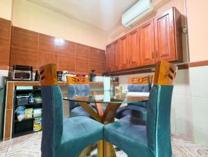 a kitchen with a glass table and blue chairs at Casa del Jaguar in Iquitos
