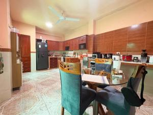 a kitchen with a table with chairs and a refrigerator at Casa del Jaguar in Iquitos