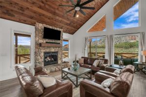 a living room with leather furniture and a fireplace at Copper Rock Ridge- Luxury, Pool Table, Hot Tub between Zion and Bryce in Orderville