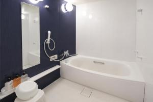 a bathroom with a white tub and a toilet at ホテルサルビア in Tendo +9 photos