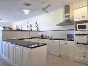 a kitchen with white cabinets and a black counter top at Willenby in Wallaroo