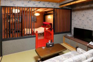 a living room with a crib with a bed at ホテルサルビア in Tendo