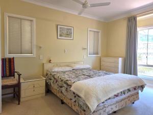 a bedroom with a bed and a dresser and windows at Willenby in Wallaroo