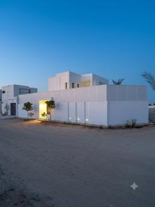 a large white building with a street in front of it at Villa blanca in Al Maqārisah