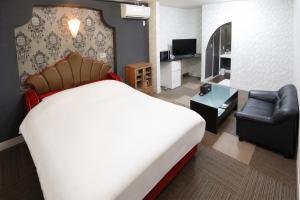 a hotel room with a large bed and a living room at ホテルサルビア in Tendo