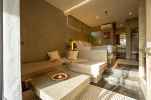 a hotel room with a bed and a couch at Panorama Villas & Suites El Nido in El Nido