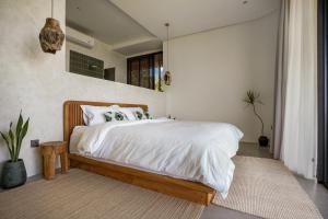 a bedroom with a bed with white sheets and pillows at Makai Lombok in Selong Belanak