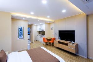 a hotel room with a bed and a television at Jeju M Resort in Seogwipo