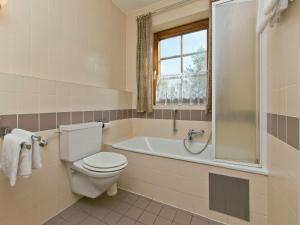 a bathroom with a toilet and a tub and a window at Chalet in Angerberg near SkiWelt Slopes in Angerberg +68 photos