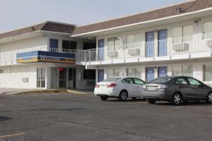 dos autos estacionados en un estacionamiento frente a un motel en Motel 6-Goodland, KS, en Goodland