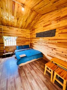 a bedroom with a bed in a wooden cabin at B & M Homes in Tả Van