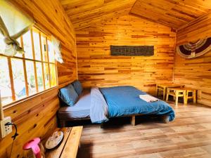 a bedroom with a bed in a wooden cabin at B & M Homes in Tả Van
