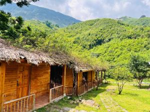 a wooden house with a deck and mountains in the background at B & M Homes in Tả Van +22 photos
